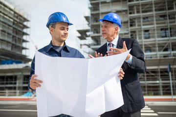 Wall Mural - Architect and site manager discussing about a drawing