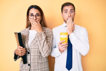 Sticker - Beautiful couple wearing business clothes drinking take away coffee holding folder covering mouth with hand, shocked and afraid for mistake. surprised expression