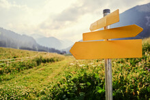 Yellow Empty Signboard With Pointer Against Beautiful Mountains Landscape, Tirol Alps, Austria.
