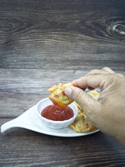 Wall Mural - Anchovies fritters or locally known as cucur bilis with chilli sauce dip. Selective focus points. Blurred background