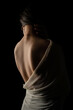 © ErdalIslak - Back view of a beautiful half naked woman. Vertical shot, isolated black background.