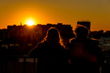 Fototapeta Londyn - A couple is watching the sunset over the city from the observation deck in Warsaw, Poland