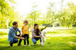© BGStock72 - Beautiful happy family is having fun with bichon dog outdoors