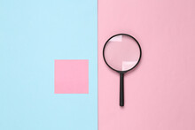 Magnifier And Memo Paper On Pink Blue Background. Search Concept