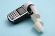 © splitov27 - Payment terminal with cash tape on blue pastel background.