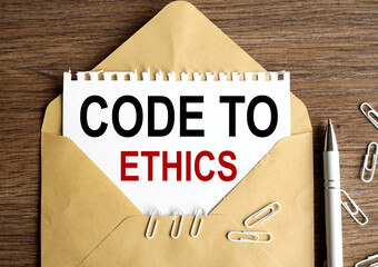 Fototapete - Code of ethics. Text on white paper. on paper in an envelope on a wooden table.