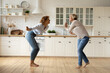 © fizkes - Happy adult daughter and senior mother dancing at modern kitchen after changing interior design moving to new house. Excited mature mom and grown female child celebrate renovation buying new furniture