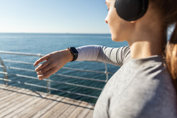 Wall Mural - Woman looking in smart watch on bright sunny day