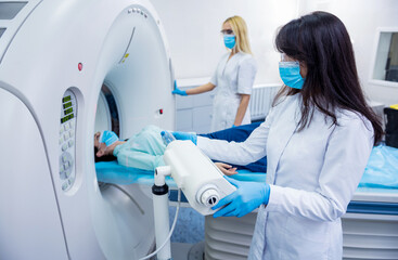 Radiologist with a female patient in the room of computed tomography