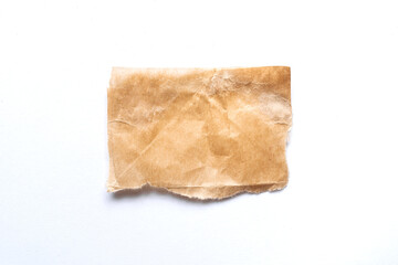 Wall Mural - close up of a ripped piece of brown spaper on white background