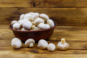 Poster - Fresh champignon mushrooms in ceramic bowl on the wooden table