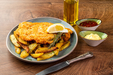 Wall Mural - schnitzel with chips on a blue plate