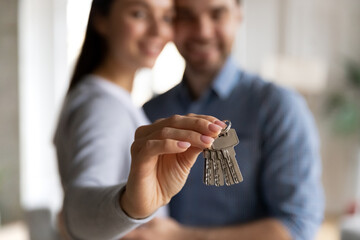 Wall Mural - Close up of door key in woman hand. Happy millennial couple just moving into new home, buying house, getting mortgage loan approval, renting apartment and start living together. Property purchase