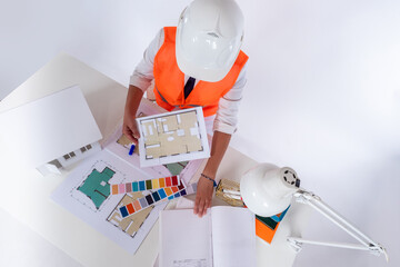 Poster - Architect is working on interior of house. Construction drawings in hands of architect. Builder at office table top view. Architect chooses color for interior. Concept - construction business.