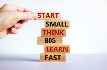 Wall Mural - Start small think big symbol. Words 'Start small think big learn fast' on wooden blocks on a beautiful white background. Businessman hand. Business, motivational and start small think big concept.