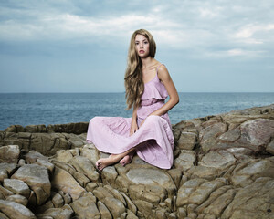 Wall Mural - Beautiful blonde woman on the beach. Lady in pink dress