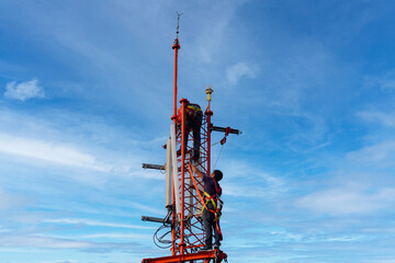 Wall Mural - Engineer maintenance on telecommunication tower doing ordinary maintenance and control to antenna for communication, 3G, 4G and 5G cellular. Cell Site Base Station on blu sky background.