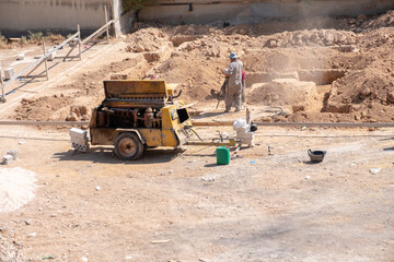 Workers are digging up the foundations for a new house according to the design in the neighborhood using compressor