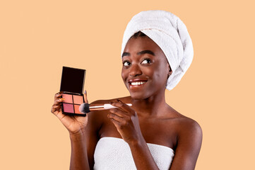 Wall Mural - Portrait of beautiful black woman applying makeup