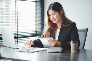 Asian young woman working on laptop in her home office