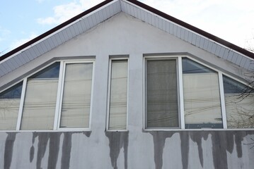 Sticker - three windows on a gray wet concrete wall in the attic of a private house