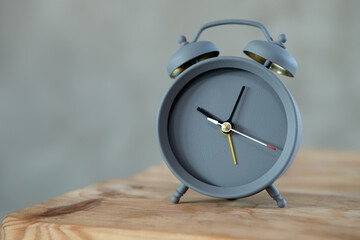 Vintage alarm clock on wooden table on grey background, copy space for text