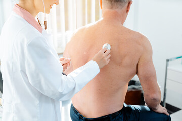 Wall Mural - Doctor using stethoscope to check lung function of man