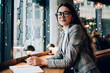 © GalakticDreamer - Smiling woman with notebook in cafeteria