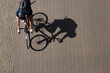 Panning shot from above of a young male riding his racing bike with sahrp shadow on the blurry pavement