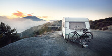 Caravan Trailer With A Bicycle Near Mountain Lake Lac De Serre-poncon In French Alps At Sunrise. Golden Sunlight, Fog. Wanderlust, Tourism, Landmark, Vacations In France. Transportation, RV, Lifestyle