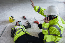 Work Accidents Of Worker In Workplace At Construction Site Area And Unconscious With Colleague Motion And Call To The Safety Officer For Rescue And Life-saving. Selection Focus On An Injured Person.