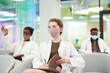 © Seventyfour - Portrait of young woman wearing mask and lab coat while listening to lecture on medicine in college or coworking center, copy space