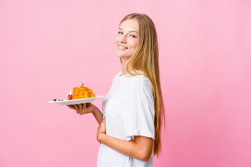 Wall Mural - Young russian woman eating a waffle isolated looks aside smiling, cheerful and pleasant.