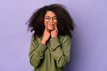 Young african american curly woman isolated on purple background doubting between two options.