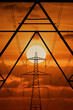 electricity pylon dramatic sunset photograph with the setting sun and an orange background carrying fossil fuel and coal powered power station generated electricity. Energy Crisis and pricing. COP26