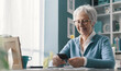 © StockPhotoPro - Happy senior lady going through old pictures