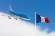 Concept travel to France. The flag of France is on blue sky. The plane is on the left.
