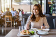 © geargodz - woman eating with food in restaurant