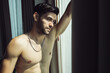 © krumanop - Handsome shirtless man have positive thinking while stand near window and looking away. Seductive attitude and nice attitude concept