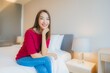 © siraphol - Portrait beautiful young asian woman smile relax on bed