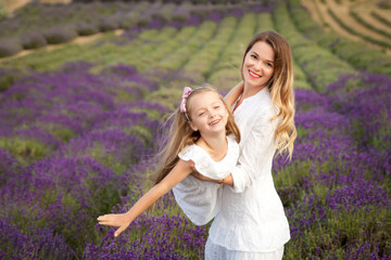 Cute little girl with her mother having fun in a lavender field