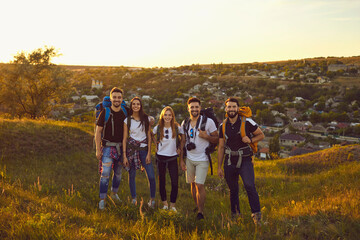 Wall Mural - portrait of a company of young friends of boys and girls hiking in the mountainous countryside.