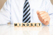 © HNFOTO - Geschäftsmann oder Projektleiter mit dem Schlagwort MINDSET als Buchstaben auf Würfeln auf dem Schreibtisch