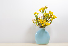 Little Yellow Flowers In Blue Vase, Still Life Background.