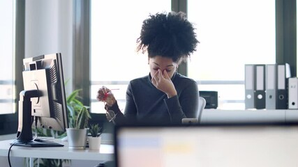 Wall Mural - Video of exhausted young afro woman with headache working with computer in the office.