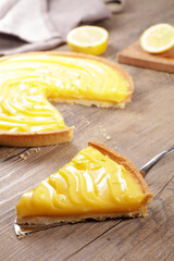 Poster - homemade lemon tart slice on wood background