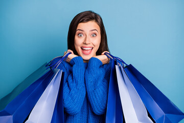 Wall Mural - photo of young happy excited cheerful good mood girl smiling hold bags after shopping isolated on bl