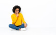 © luismolinero - Young African American woman sitting on the floor with glasses and smiling