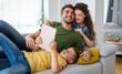 © NDABCREATIVITY - Happy family using technology devices together at home.