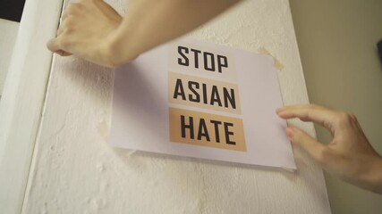 Wall Mural - Stop Asian Hate sign attached on the wall